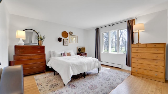 bedroom featuring a baseboard radiator and light wood finished floors