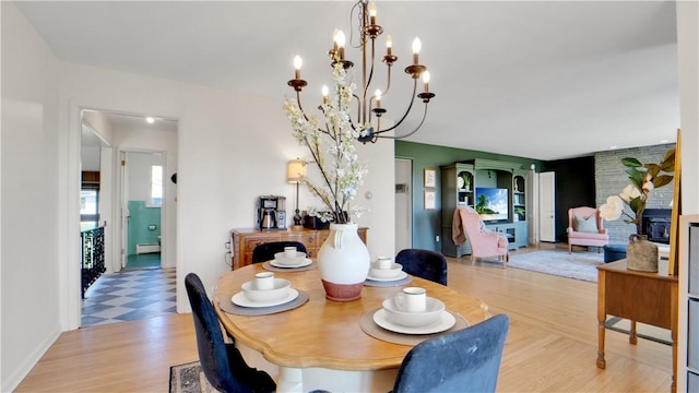 dining room with a baseboard heating unit, an inviting chandelier, and light floors
