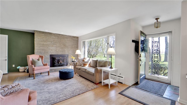 living area with baseboard heating, a brick fireplace, recessed lighting, baseboards, and wood finished floors
