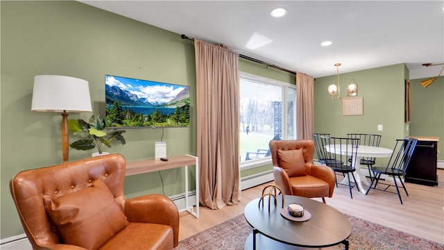 living area with baseboard heating, recessed lighting, baseboards, and wood finished floors