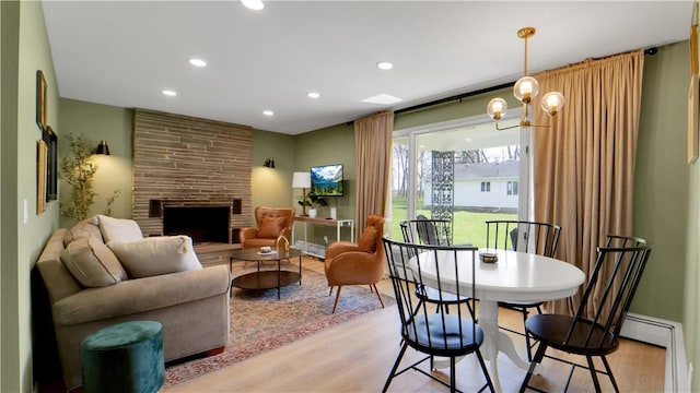 interior space featuring recessed lighting, a stone fireplace, and light wood finished floors