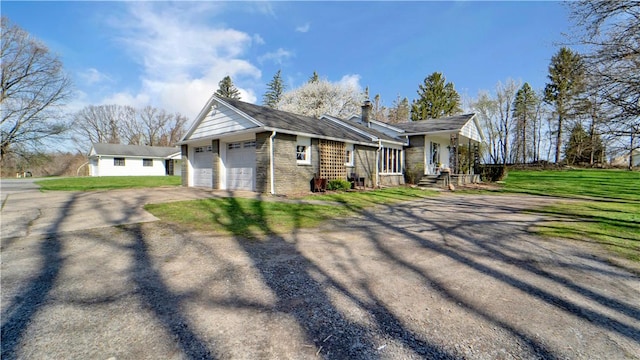 view of side of property with a garage, a yard, and driveway