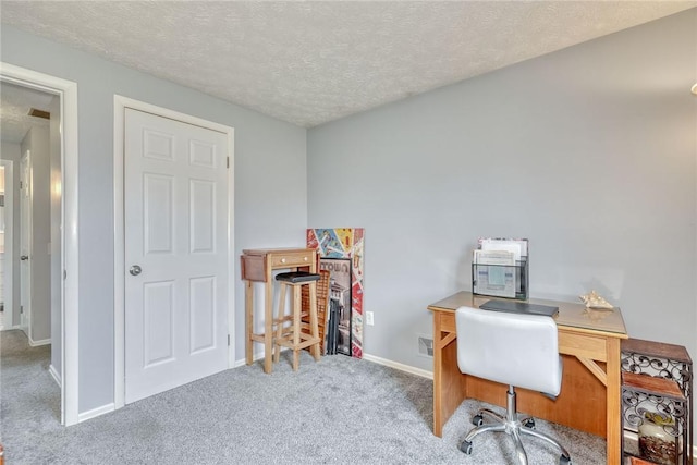 office featuring a textured ceiling, baseboards, and carpet floors