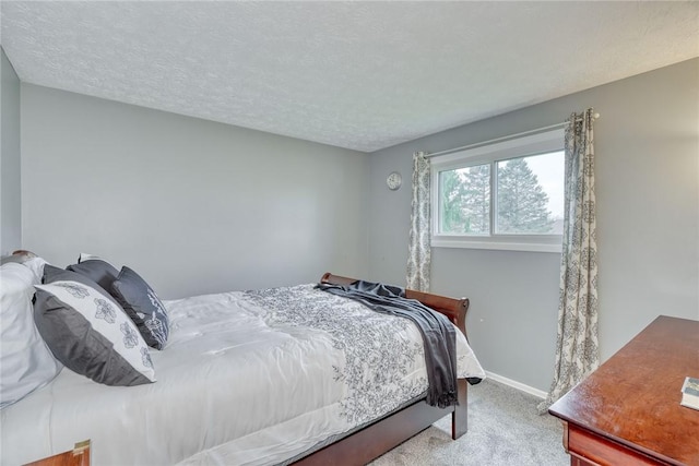carpeted bedroom featuring a textured ceiling and baseboards