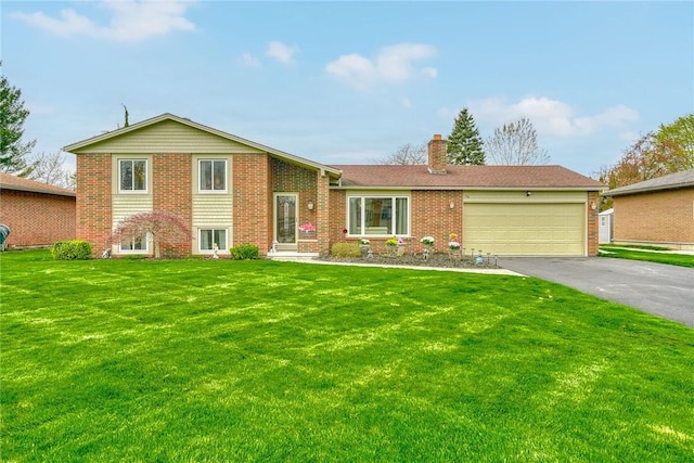 split level home featuring driveway, a chimney, a front yard, and a garage