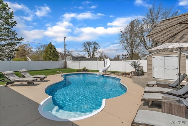 view of swimming pool with a fenced backyard, a fenced in pool, a water slide, and a patio