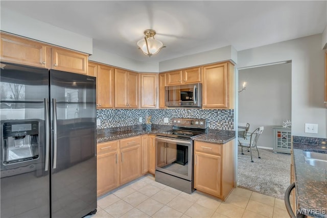 kitchen with dark stone counters, tasteful backsplash, and stainless steel appliances