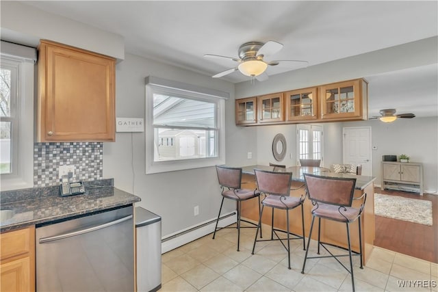 kitchen featuring decorative backsplash, a baseboard radiator, stainless steel dishwasher, and a ceiling fan