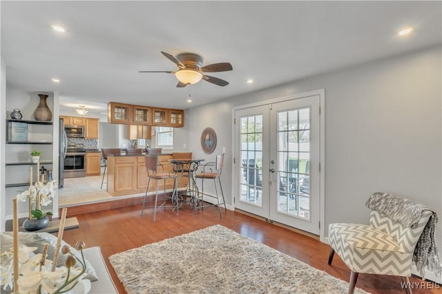 living room with light wood-style floors, a ceiling fan, french doors, and recessed lighting