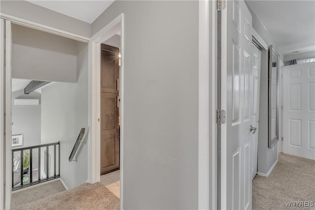 corridor featuring light colored carpet, a wall mounted AC, and an upstairs landing