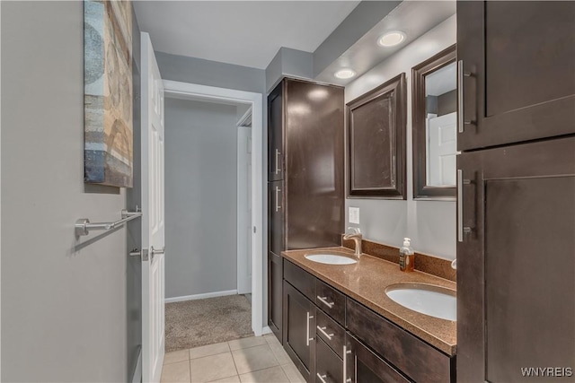 bathroom featuring a sink, tile patterned floors, recessed lighting, and double vanity