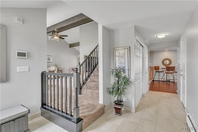 stairs with tile patterned flooring, a baseboard radiator, baseboards, and a ceiling fan