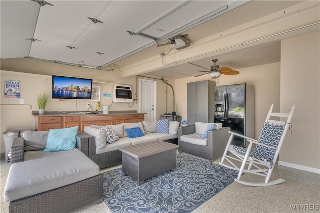 living room featuring baseboards, ceiling fan, heating unit, and speckled floor