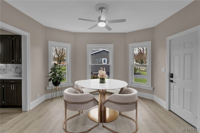dining area featuring ceiling fan, light wood-style flooring, and baseboards