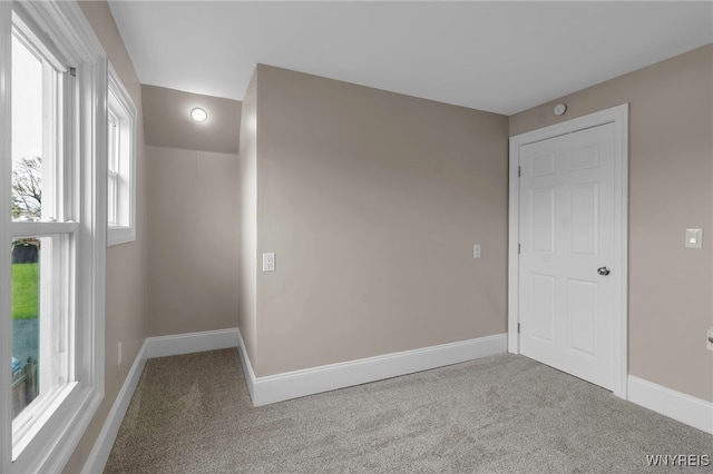 spare room featuring a wealth of natural light, carpet floors, and baseboards