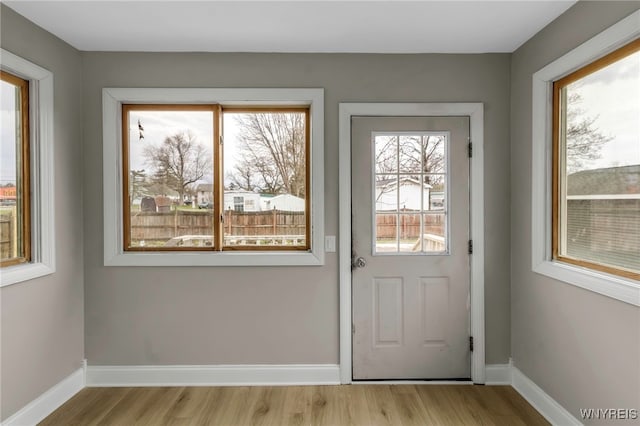 entryway with light wood-type flooring and baseboards