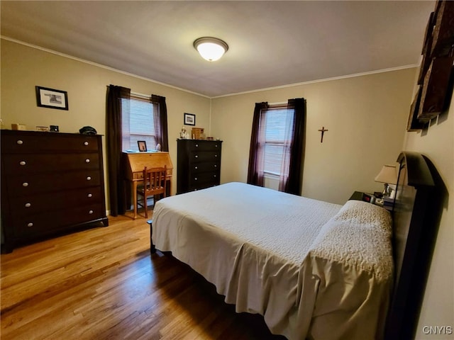 bedroom featuring crown molding and light wood-type flooring