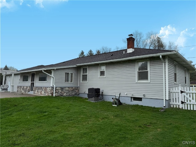 back of property with a lawn, a patio, fence, and a chimney
