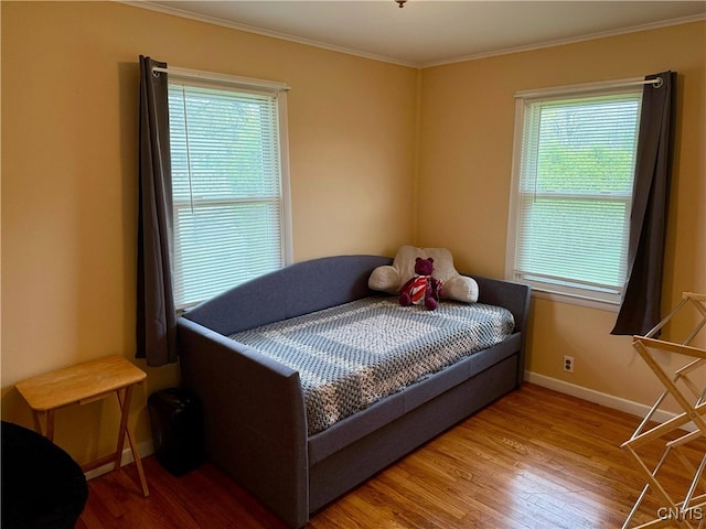 bedroom featuring crown molding, baseboards, and wood finished floors