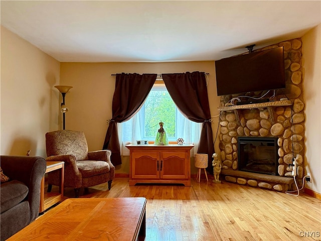 living area featuring light wood-type flooring and a fireplace