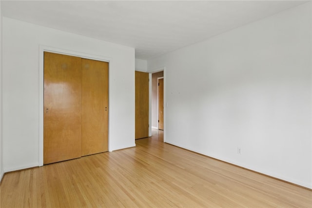 unfurnished bedroom featuring a closet and light wood-style flooring