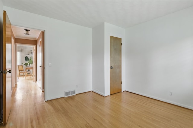 unfurnished room with baseboards, light wood-style flooring, and visible vents