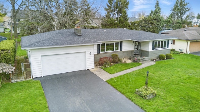 single story home featuring roof with shingles, an attached garage, aphalt driveway, a front yard, and a chimney