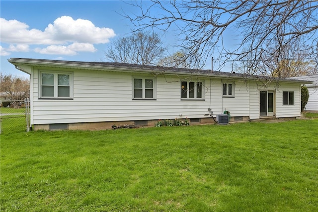 rear view of house featuring a lawn, fence, and central air condition unit