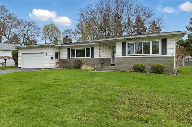 single story home featuring a garage, a front lawn, driveway, and a chimney