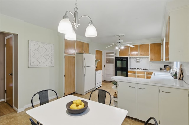 dining area featuring baseboards and ceiling fan with notable chandelier