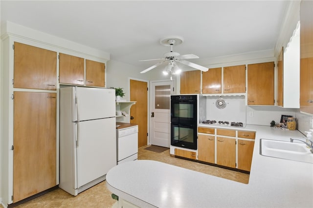 kitchen with a sink, white appliances, light countertops, a ceiling fan, and a peninsula