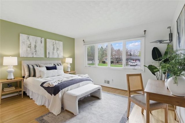 bedroom featuring visible vents and light wood-style flooring