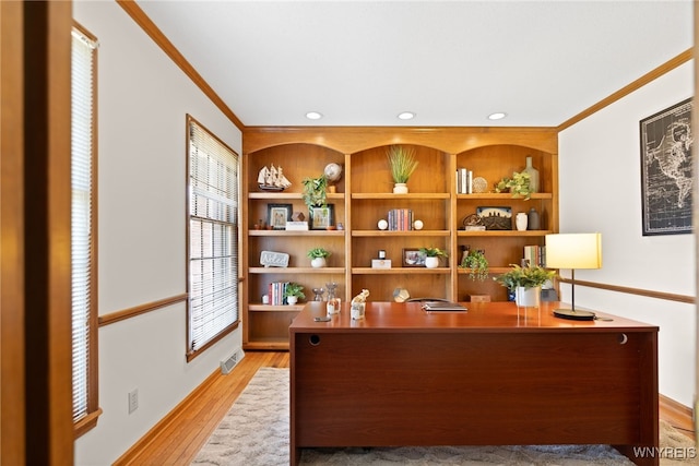 office featuring crown molding, baseboards, visible vents, and light wood-type flooring