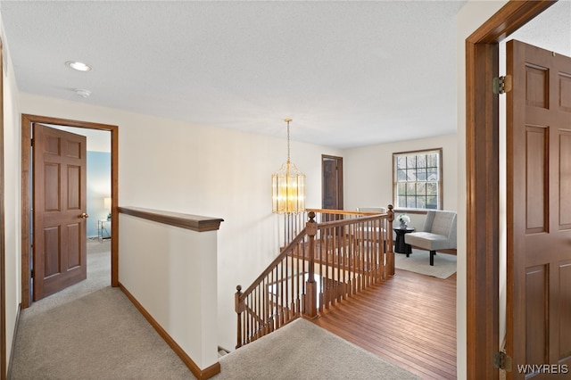 corridor featuring carpet flooring, recessed lighting, baseboards, and an upstairs landing