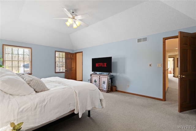 bedroom featuring visible vents, lofted ceiling, baseboards, light colored carpet, and a ceiling fan