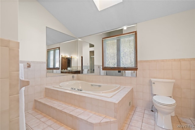 full bath with tile patterned floors, wainscoting, and tile walls
