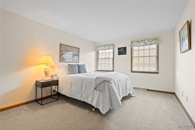carpeted bedroom with visible vents and baseboards