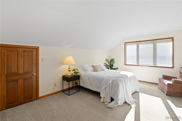 bedroom featuring baseboards, light colored carpet, and lofted ceiling
