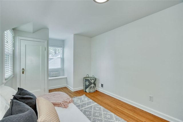bedroom featuring baseboards, visible vents, and wood finished floors