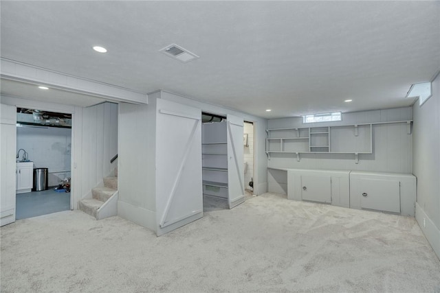 finished basement with carpet flooring, recessed lighting, visible vents, and stairway