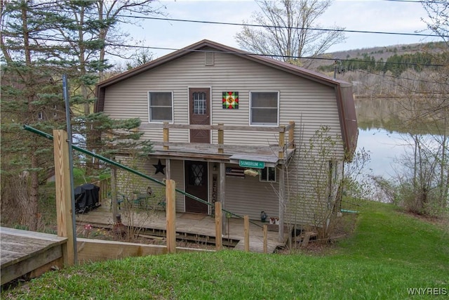back of property featuring a wooden deck and a yard