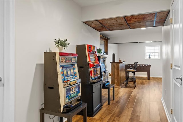 rec room with baseboards and wood finished floors