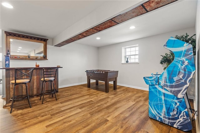 rec room with baseboards, recessed lighting, wet bar, and wood finished floors