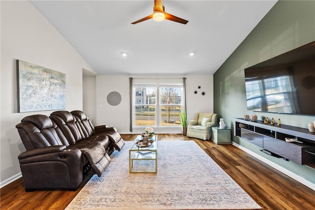living area with ceiling fan, dark wood finished floors, baseboards, and lofted ceiling