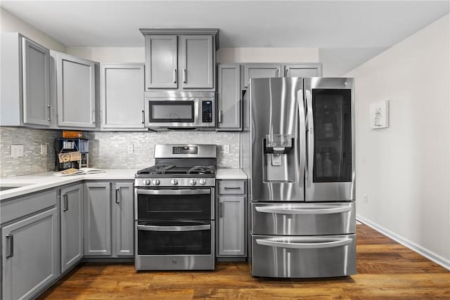 kitchen with appliances with stainless steel finishes, gray cabinets, and decorative backsplash
