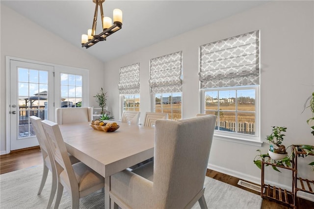 dining space with an inviting chandelier, visible vents, lofted ceiling, and a wealth of natural light