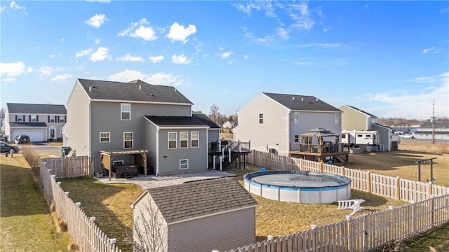 rear view of property featuring a fenced in pool, a fenced backyard, and a residential view