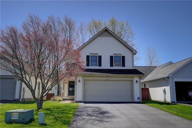 traditional-style home with an attached garage, a front lawn, and driveway