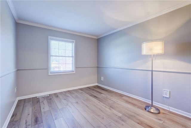 unfurnished room with crown molding, baseboards, wood finished floors, and visible vents