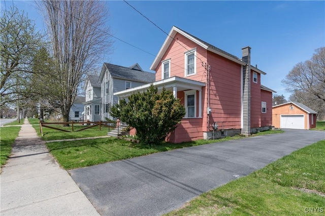 427 S James St, Wilna, NY 13619 - view of side of property featuring a garage, an outdoor structure, a chimney, and a yard